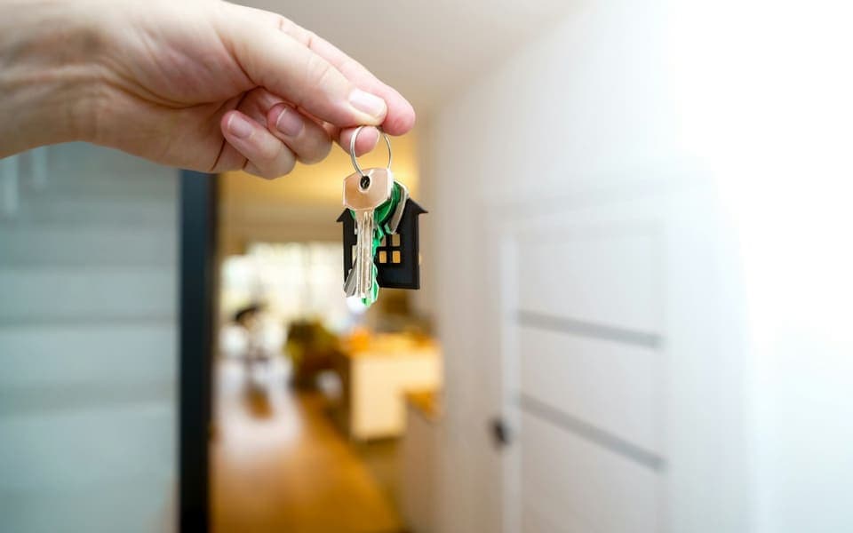 A hand holding the keys to a new home